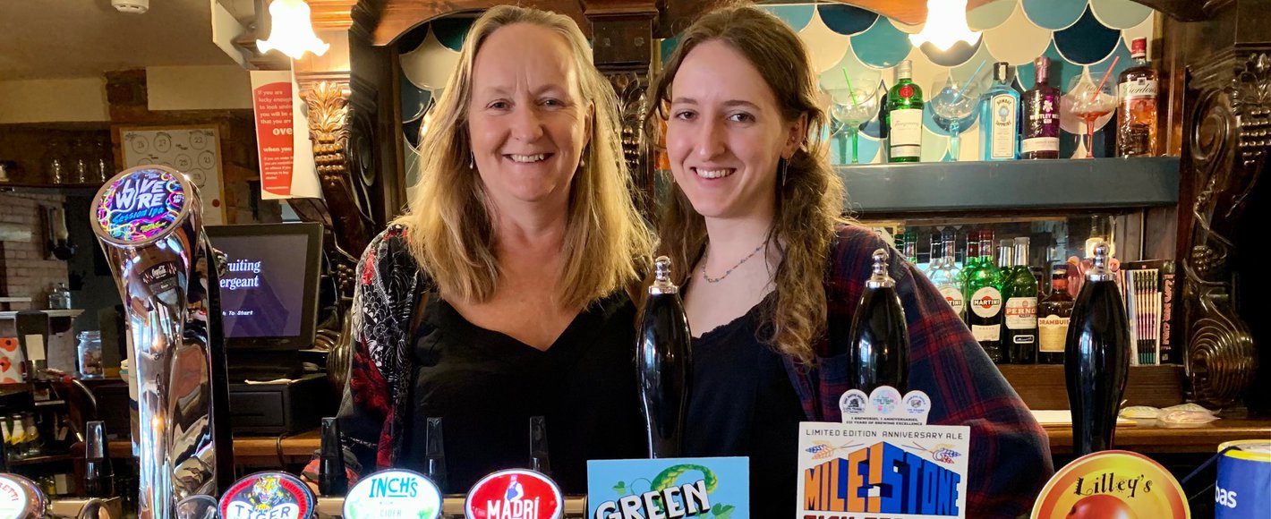 mother and daughter behind the bar serving