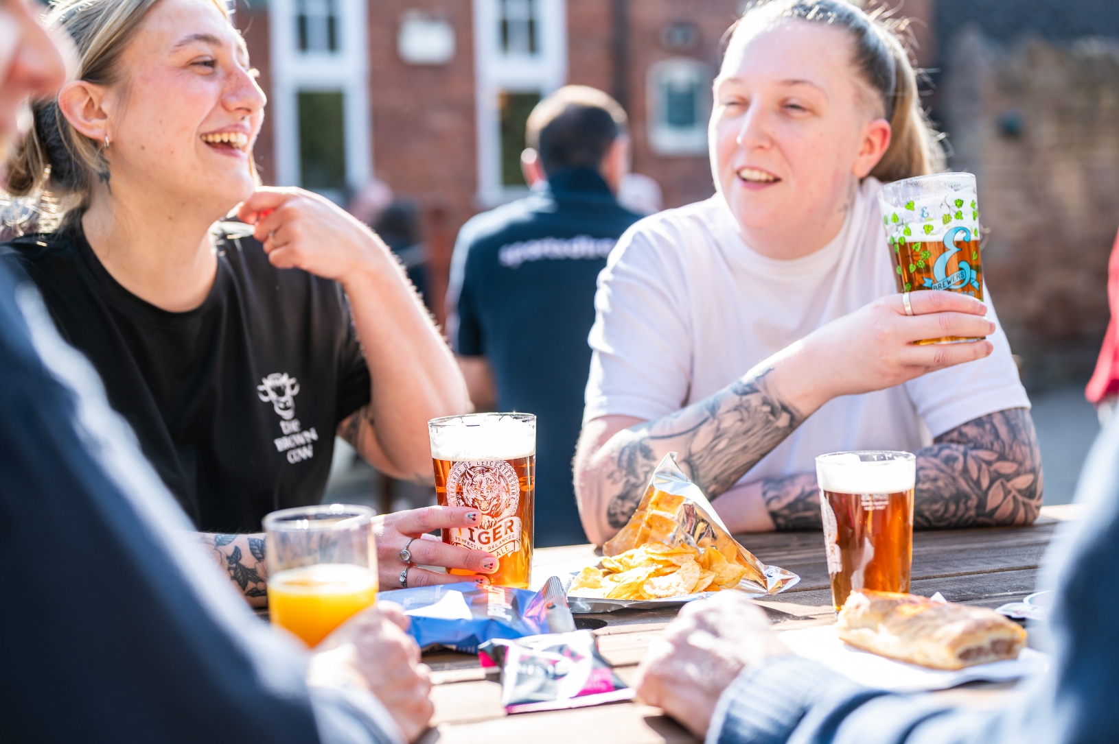 two women in beer garden enjoying snacks and beer